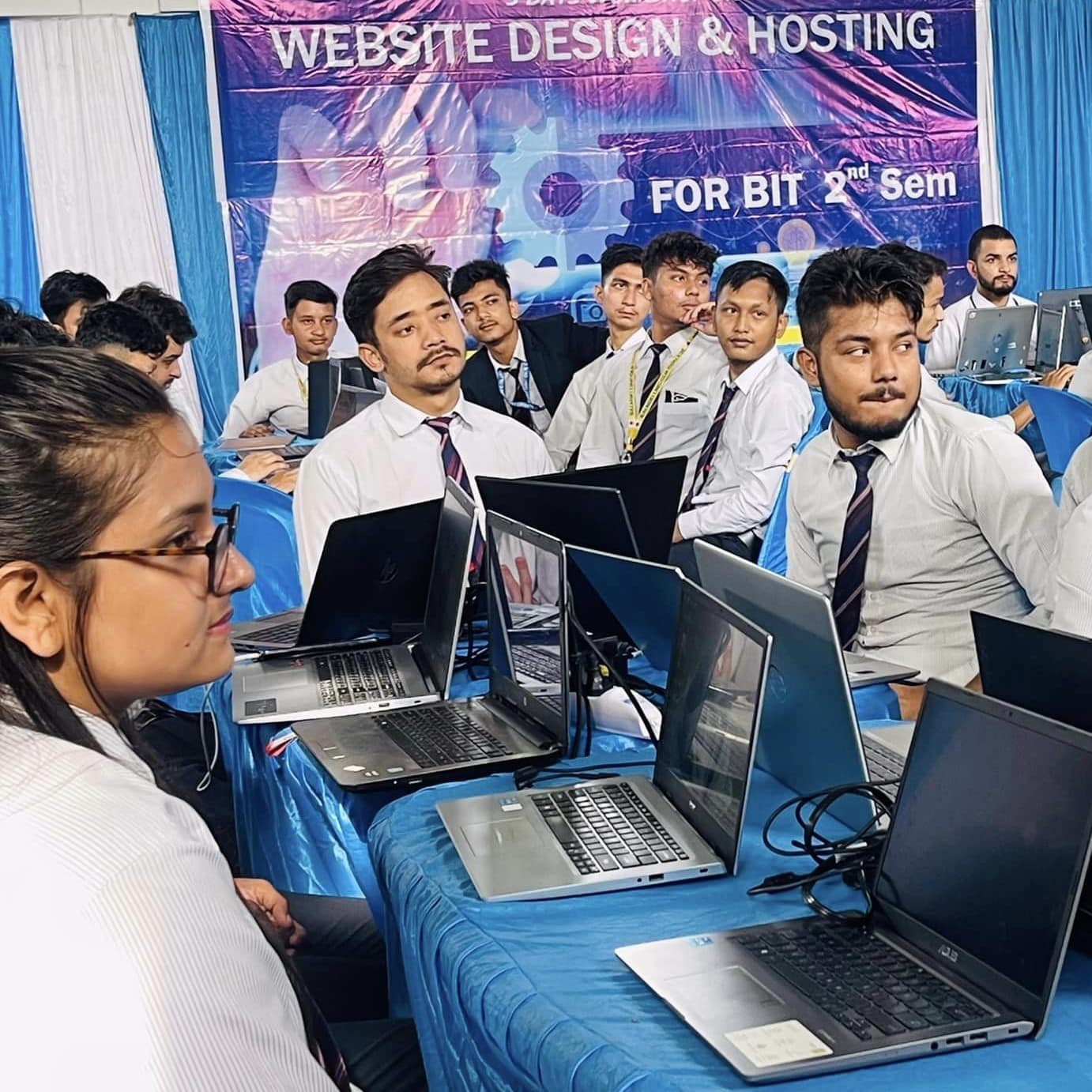 Students working on computers in a modern lab, illustrating IT curriculum